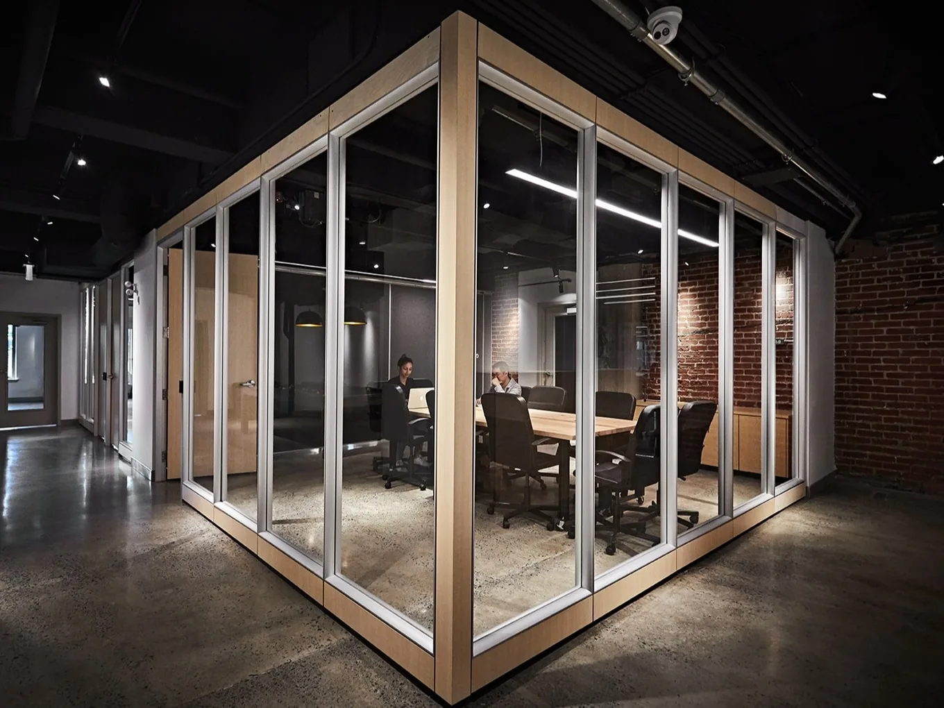 Glass meeting room with exposed brick in the Webtec workspace